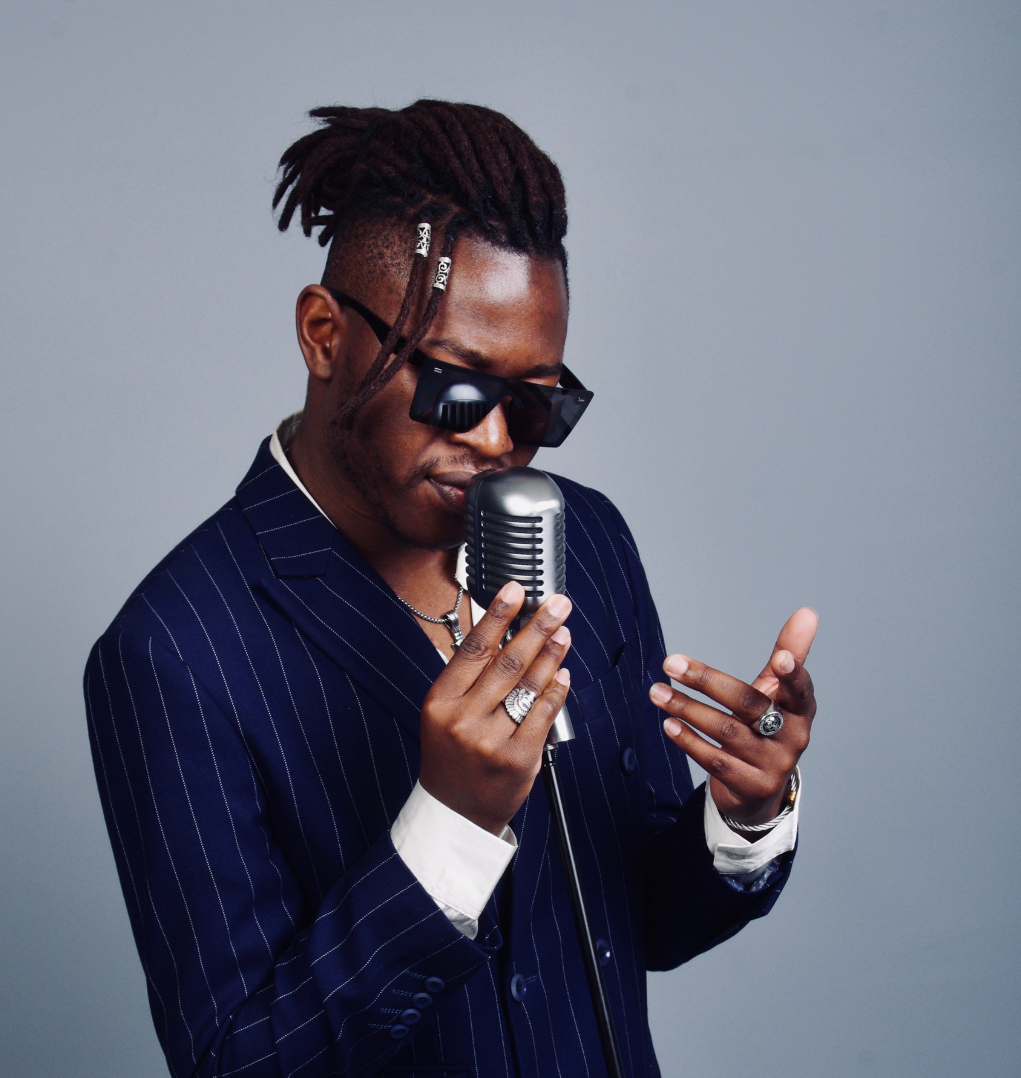 Eric Maseko singing in a pinstripe suit