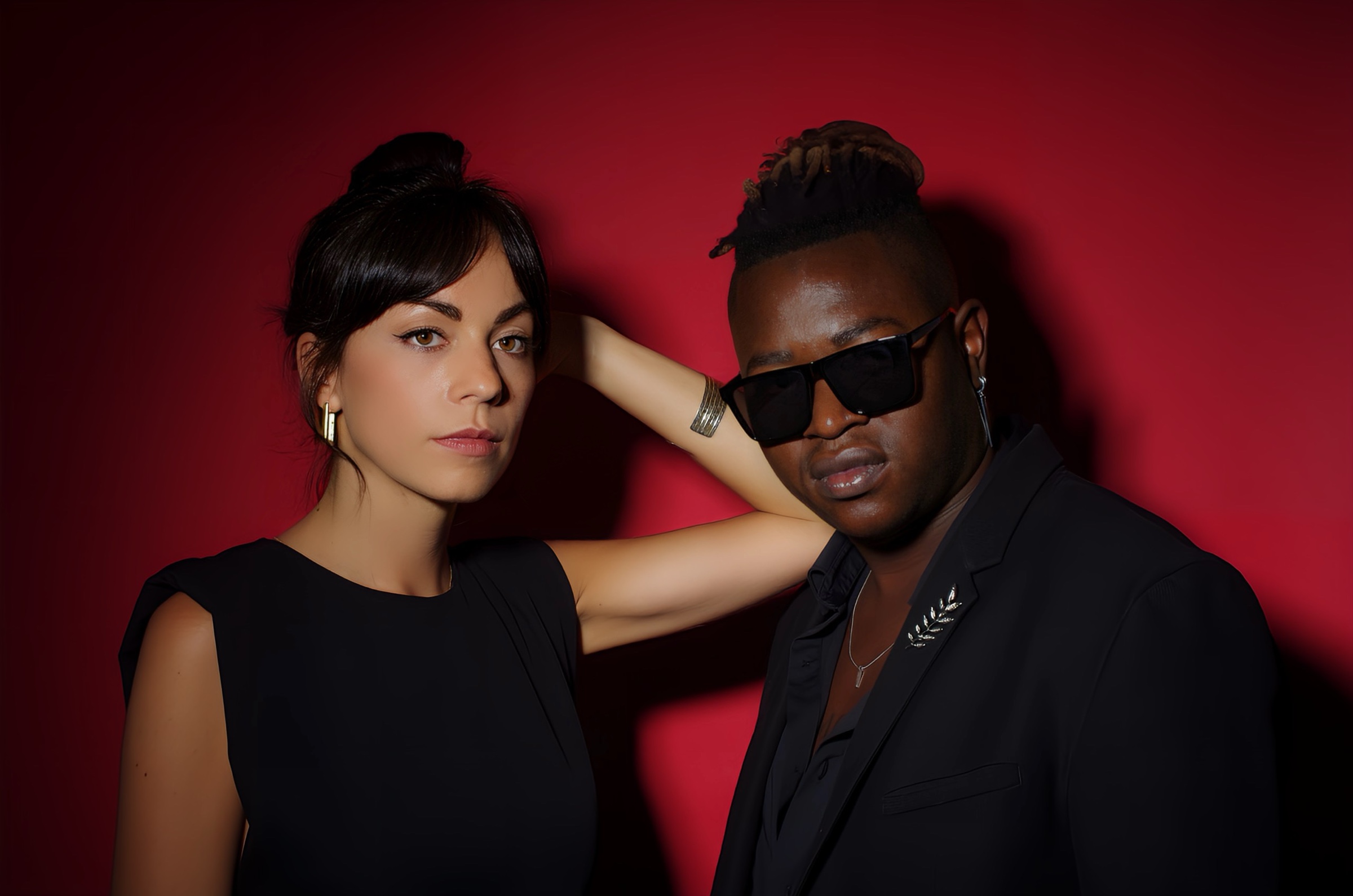 Portrait of Marie Oya and Eric Maseko against a red backdrop