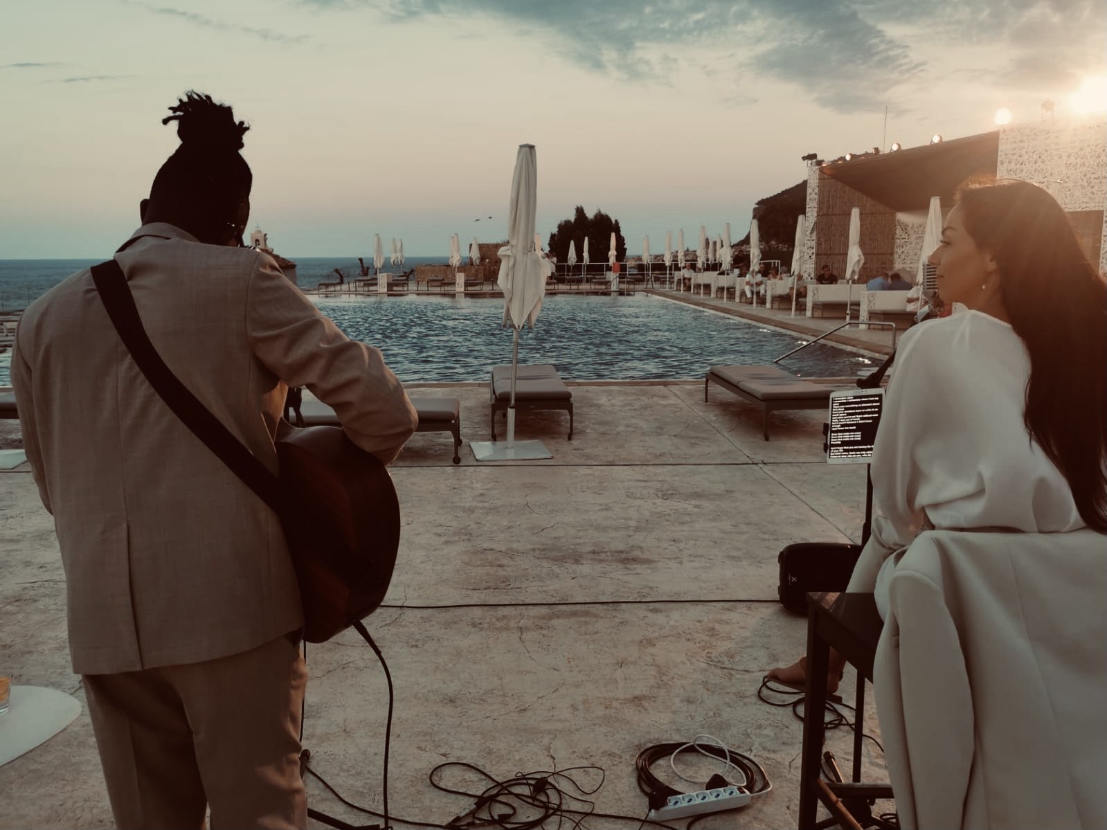 Duo musical au bord d'une piscine au coucher du soleil