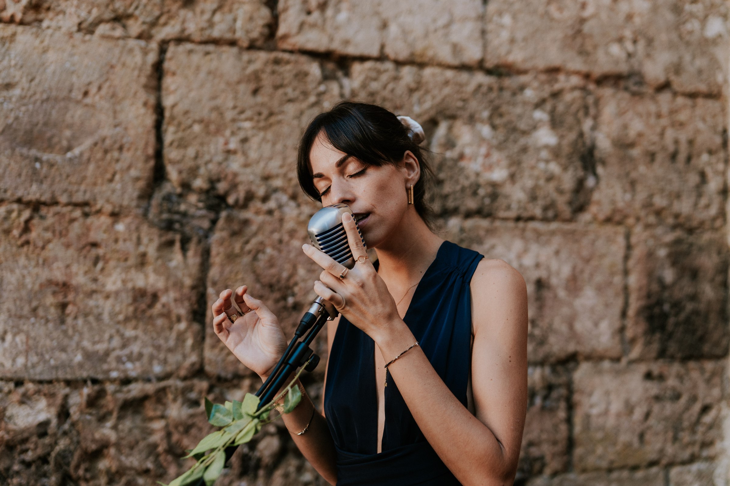 Marie singing against a stone wall