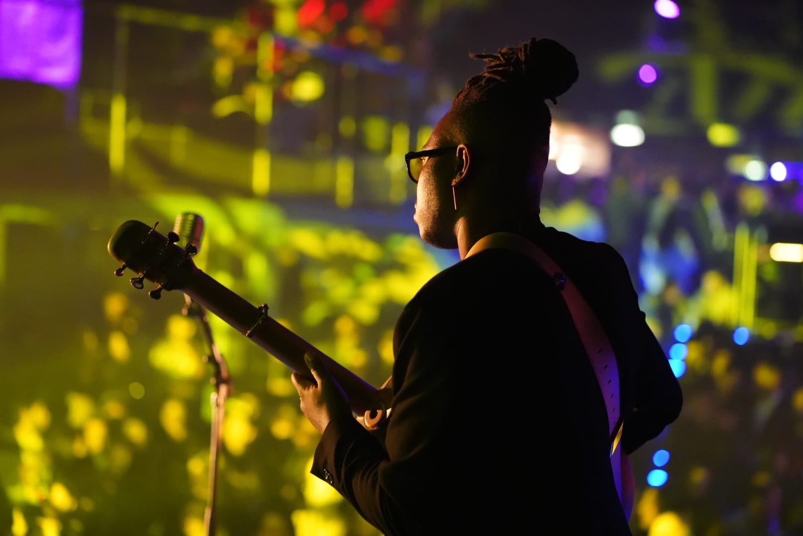 Eric Maseko playing guitar beneath concert lights